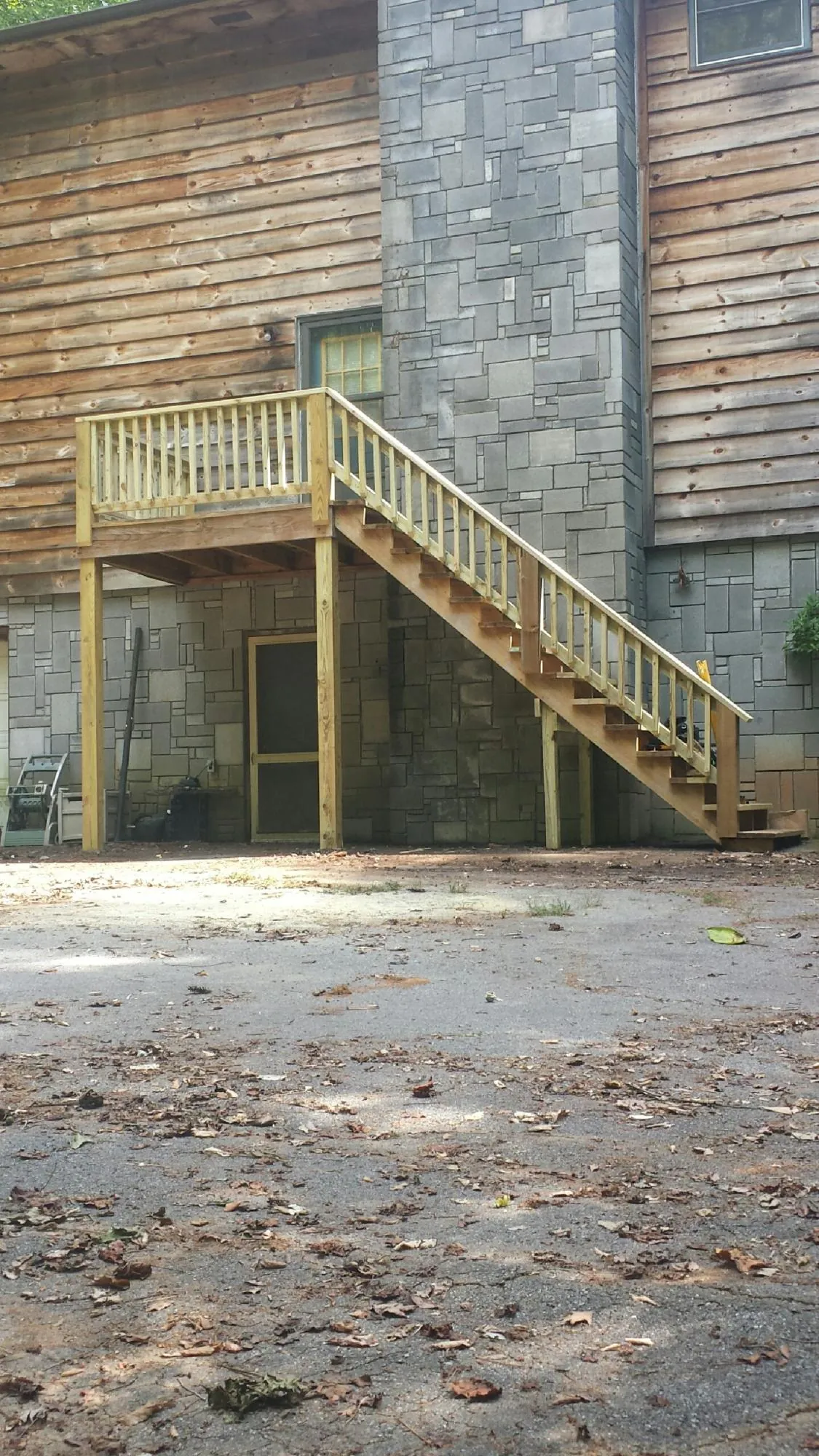 New pressure treated deck and stair landing on a log home in Cottage Grove
